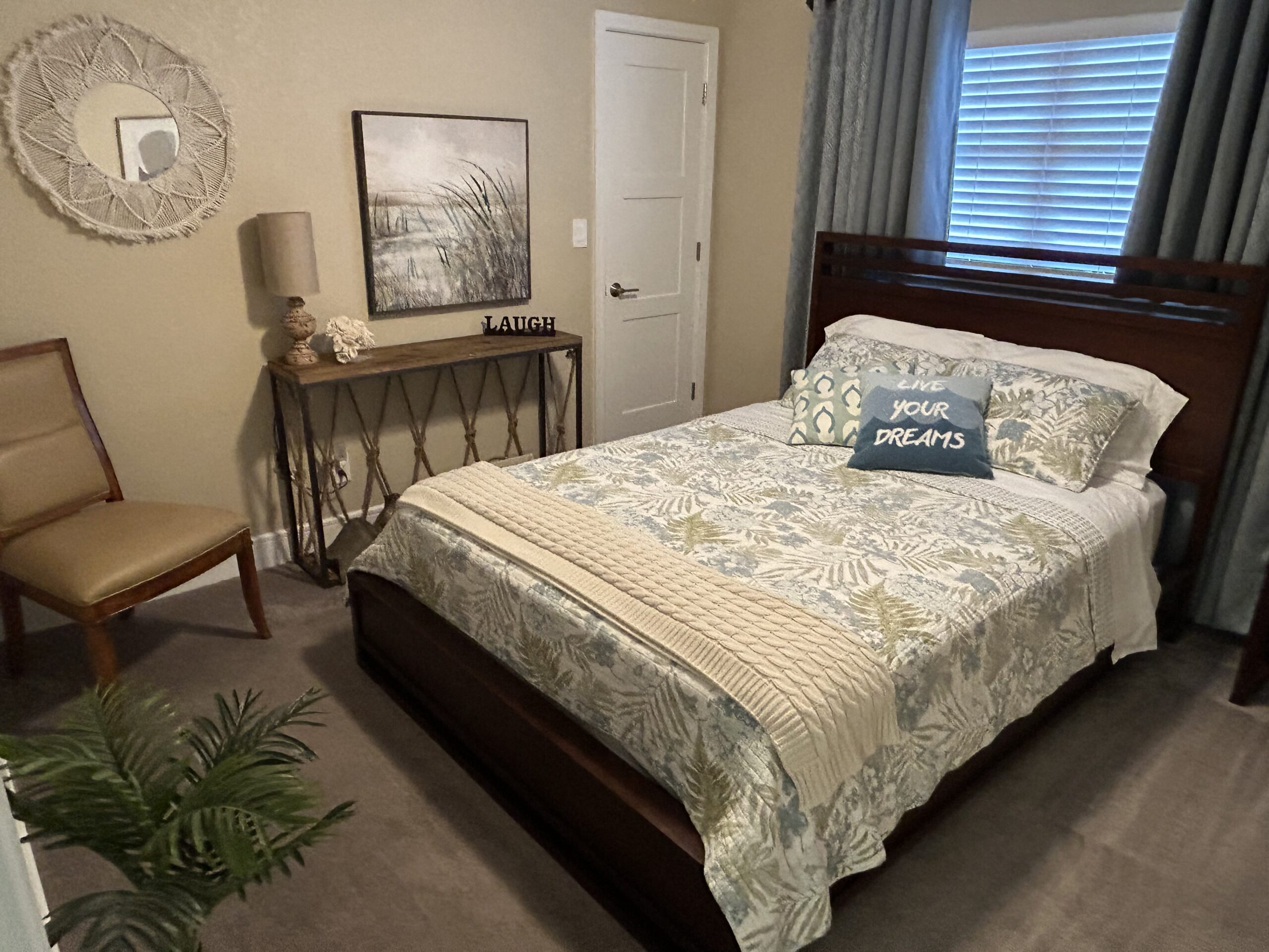 Guest bedroom with queen bed, coastal décor, and natural light in Clearwater Sand Key monthly condo rental