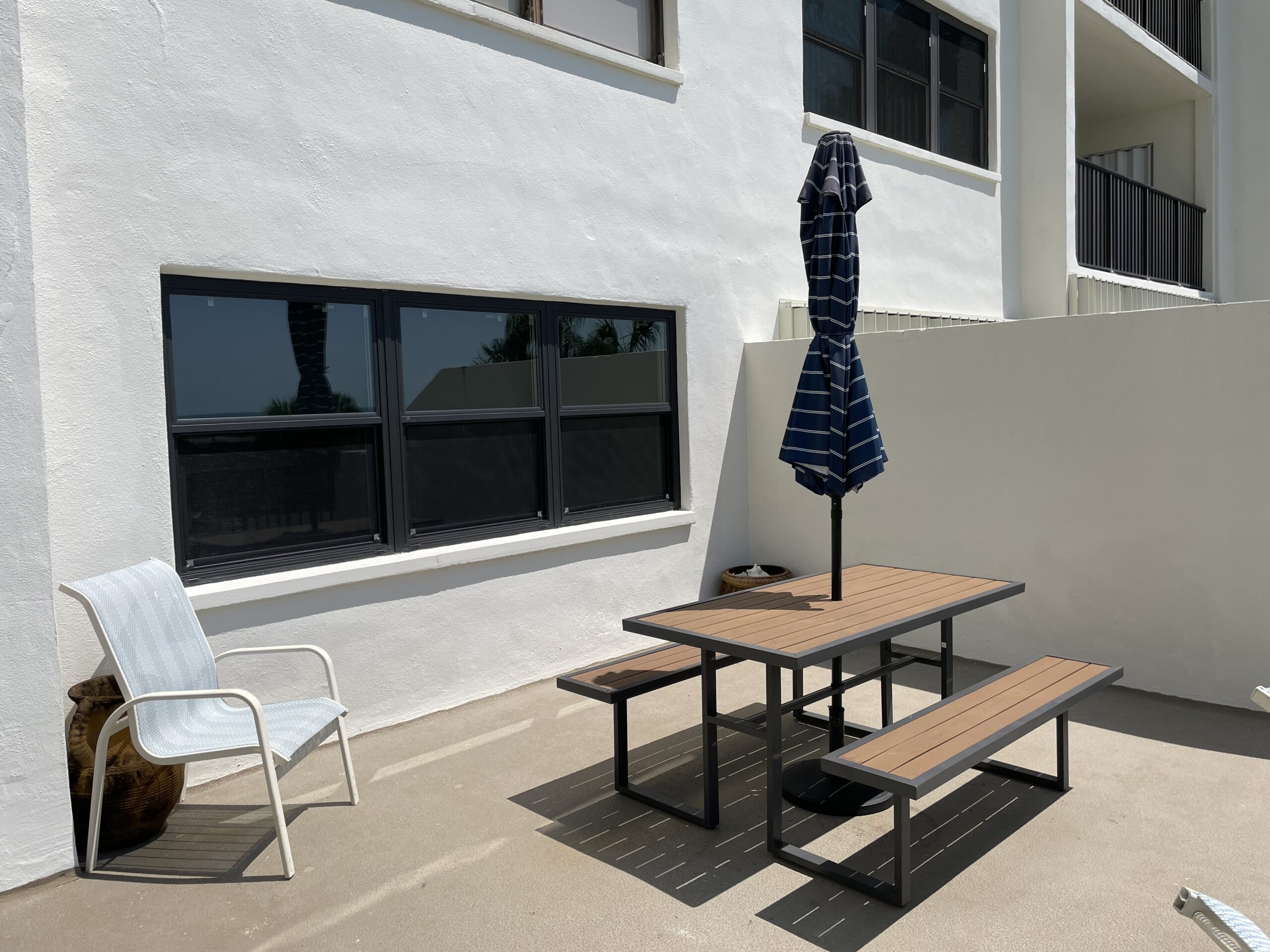 Private balcony with outdoor dining area overlooking the gulf and outdoor amenities at Sand Key Clearwater condo