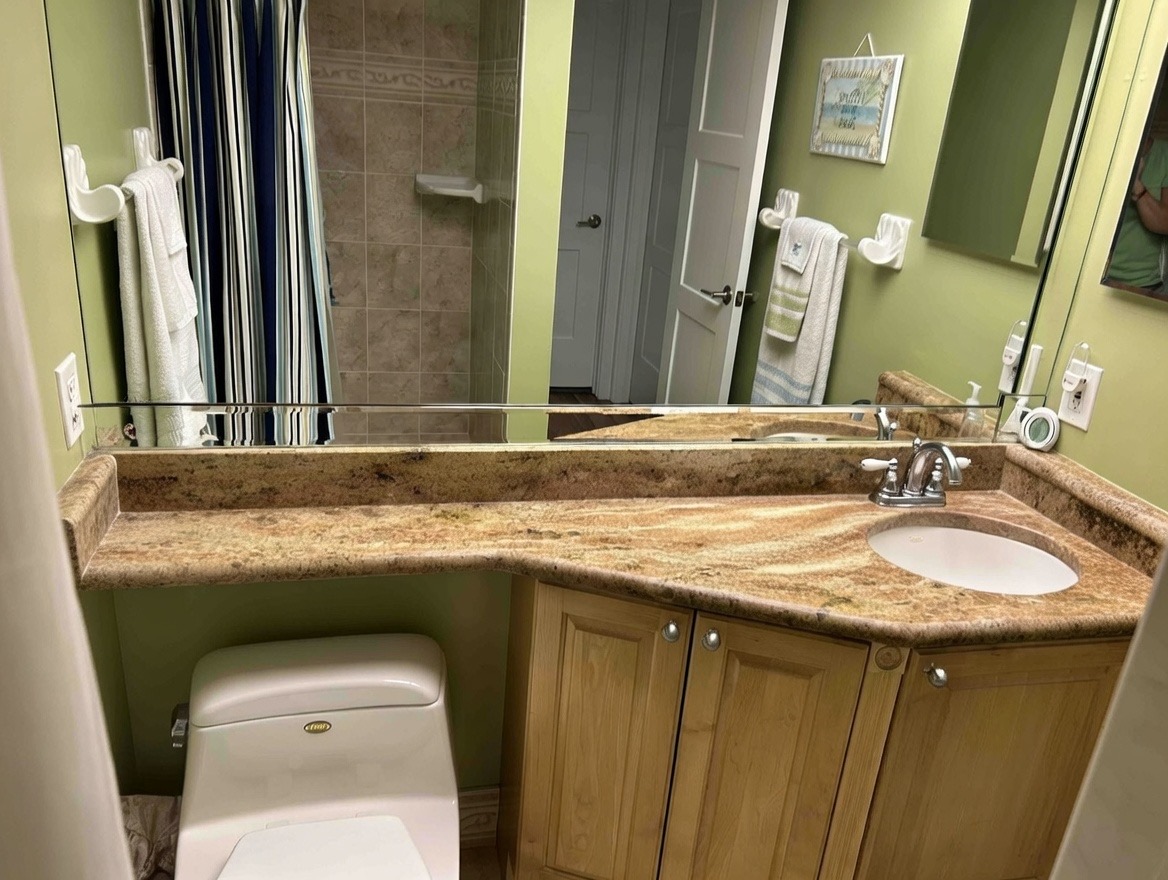 Guest bedroom with queen bed, coastal décor, and natural light in Clearwater Sand Key monthly condo rental